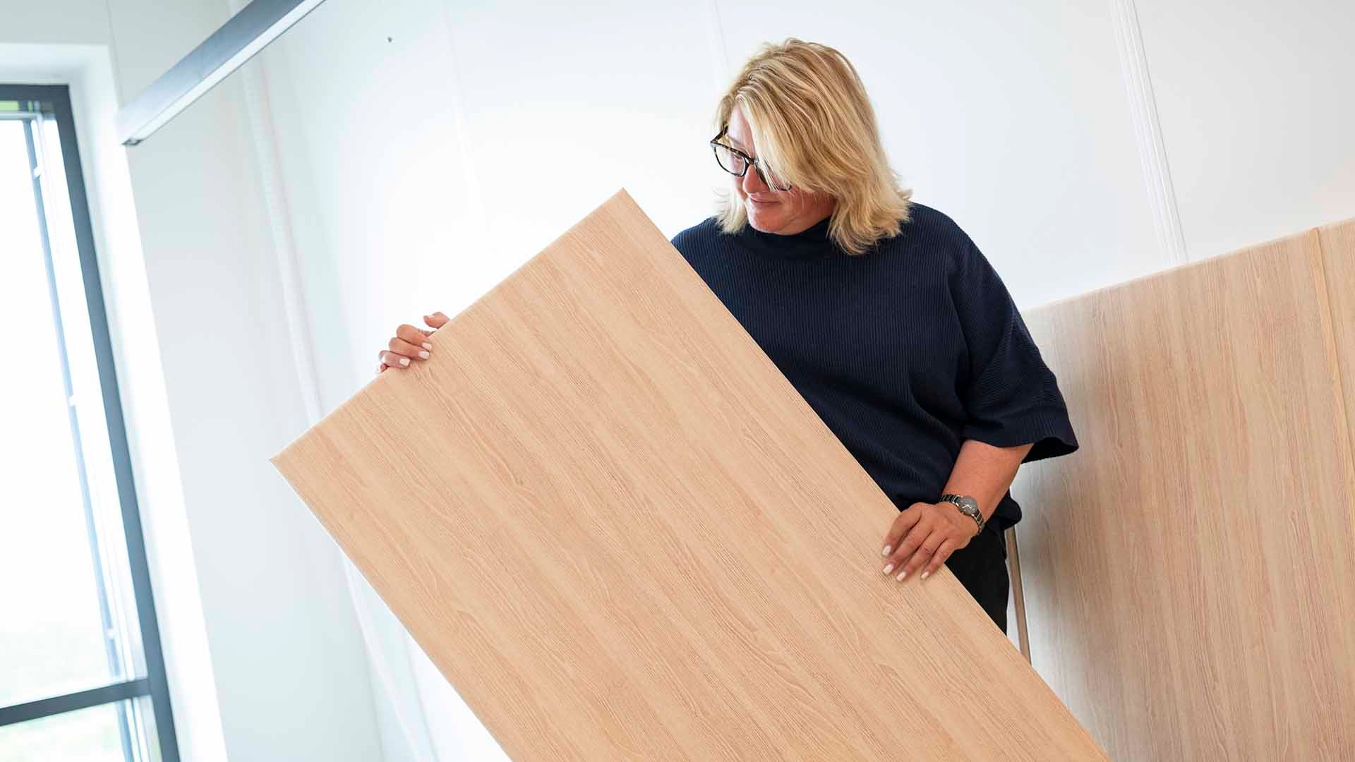 Frøydis viser noen av de lyddempende platene som selges både til bedrifter og private. Foto: Markus Johannsson/Bitmap